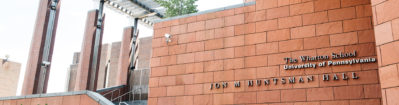 Facade of Jon M. Huntsman Hall at The Wharton School, University of Pennsylvania, featuring modern architectural elements with reddish-brown tiles.